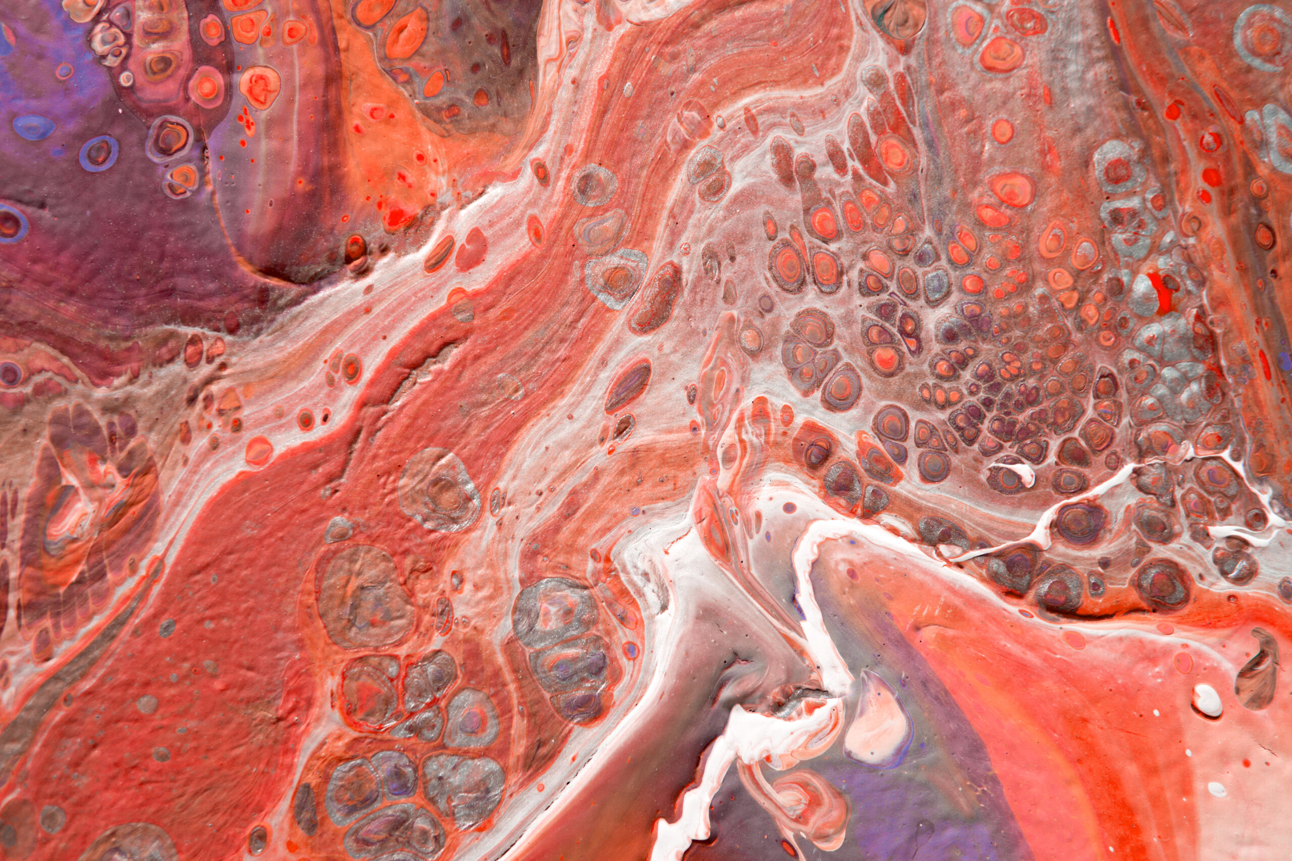 Spread-out acrylic paint. Abstract background, made in the technique of fluid art. Fashionable colorful background in warm colors